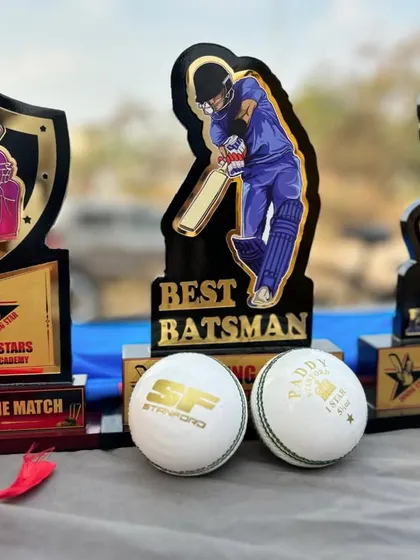 A close-up of the spoils of victory. The trophies and match balls for Man of the Match, Best Batsman, and Best Bowler from our anniversary tournament.