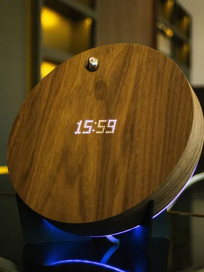 The STORY timepiece combines its orbiting sphere with a practical digital display that can be seen through the wood. This close-up shows the clock function, which can be set to display the time or act as a timer.