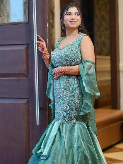 A stunning party look in a green fish-cut lehenga. The makeup features a bold eye to match the glamorous outfit.