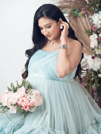 A close-up of a client in our Eva gown, holding a bouquet of peonies. The soft colors of the dress and flowers are a perfect match.