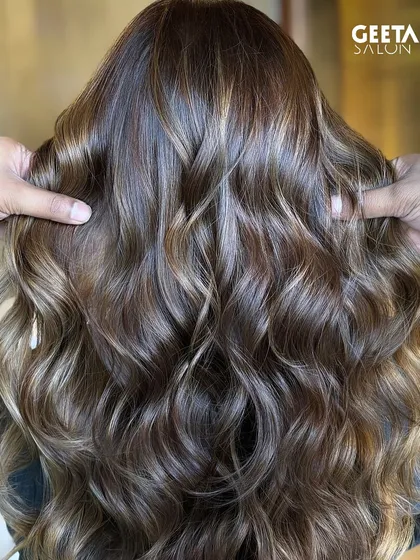 A close-up of a blonde balayage, with our stylist's hands showing the texture and dimension of the colour.