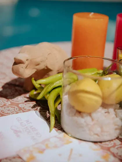 A close-up of the thematic decor elements, including lemons, chillies, and pink salt, arranged artfully on a side table by the pool.