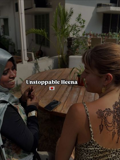 A candid moment of conversation and connection while applying henna. This art is not just about design, it's a therapeutic experience. The text 'Unstoppable Heena' reflects my belief in my craft.