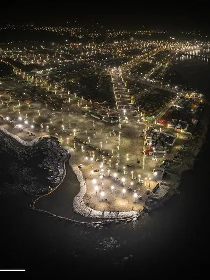 The full expanse of the Sangam area in Prayagraj, illuminated at night. This shot shows the beautiful layout of the ghats and pathways along the river.