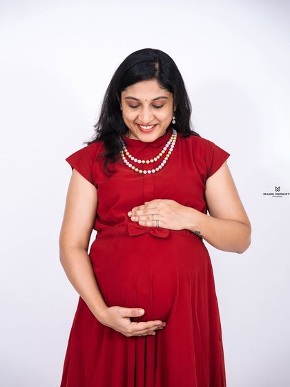 A joyful solo portrait of the mother-to-be. Her smile as she looks down at her belly is a perfect expression of the love she already feels.