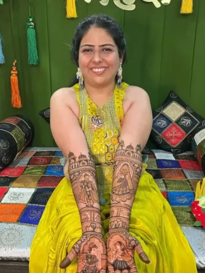 A happy bride displaying her intricate story-based mehndi design.