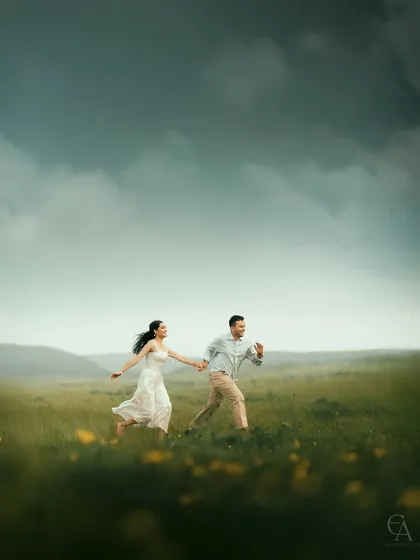 A candid shot of a couple running hand in hand through a vast, open field. This captures the energy, freedom, and pure happiness of being together.