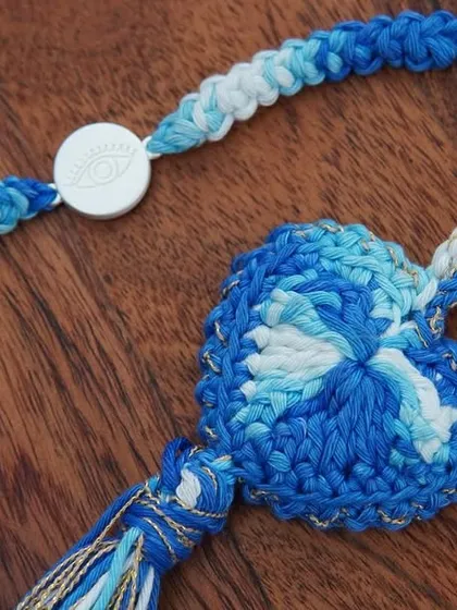 A close-up of the blue Lumba, showing the beautiful shades of blue yarn and the delicate pearl details.