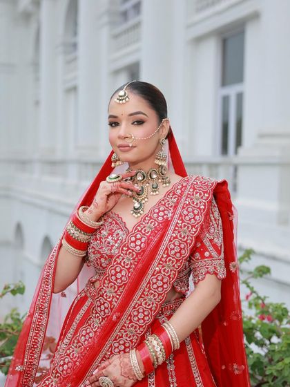 The bride in her full glory, with the red dupatta framing her face. This is a classic bridal shot that never goes out of style.