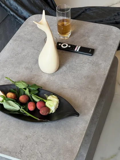 A close-up on the details. The modern, grey-toned coffee table is styled with simple, elegant decor, reflecting the calm and sophisticated mood of the living room.