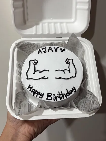 A fun bento cake for a fitness lover, featuring hand-drawn biceps. A great way to personalize a birthday wish for a gym enthusiast.