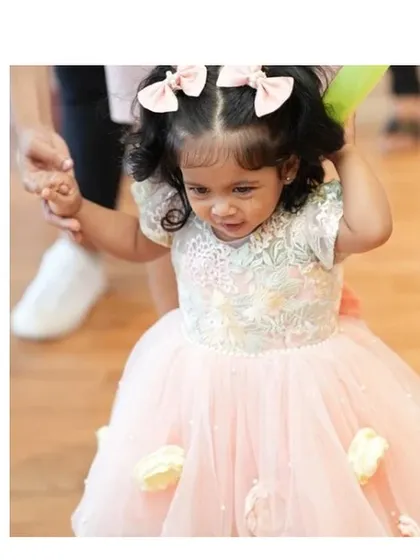 A sweet girl in our "Spring Flowers" dress. The soft pastel colors and delicate embroidery are perfect for her, and her happy expression says it all.