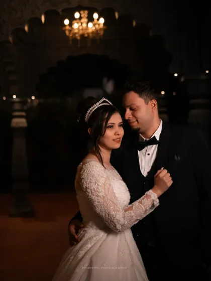 An intimate dance in a softly lit hall. We focus on the quiet moments of connection between the couple.