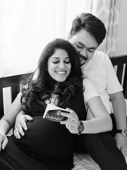 The pure joy of looking at their baby's first photo together. This black and white image captures a priceless reaction, a memory they will cherish forever.
