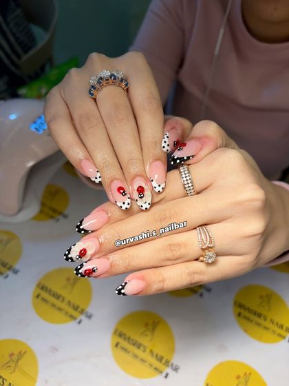 This cute and classy set features hand-painted polka dots and tiny ladybugs. The design uses a modern French tip style in black and white, with the playful bugs adding a whimsical touch.