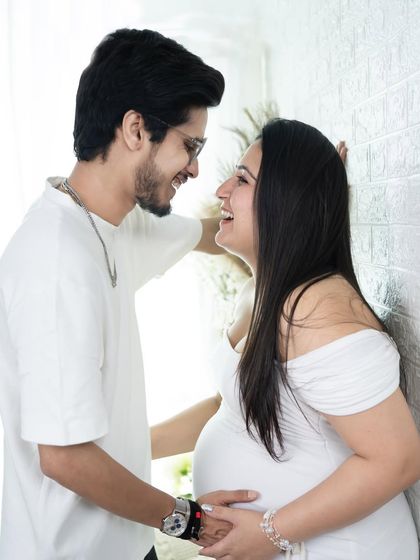 A candid and joyful moment between an expecting couple. Their shared laughter makes this a heartwarming and authentic portrait.