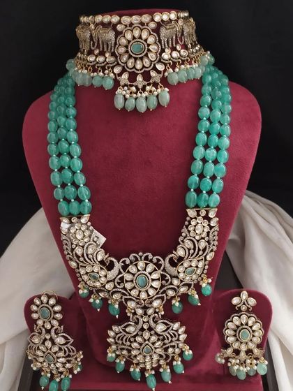 This Victorian set in a vibrant green features a choker with elephant motifs and a stunning layered necklace. The matching earrings are equally grand.