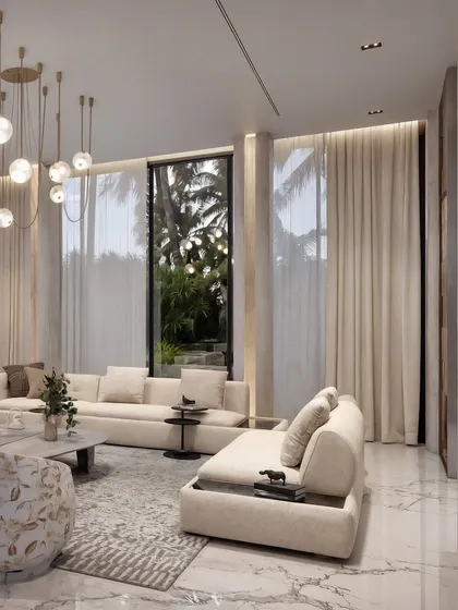 A detail shot of the seating area, showing the contrast between a floral-patterned armchair and the neutral sofa.