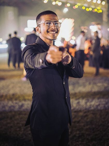 Pointing to a guest at an outdoor evening event. Close-up magic is all about connection and making each person feel like they are the center of the moment.