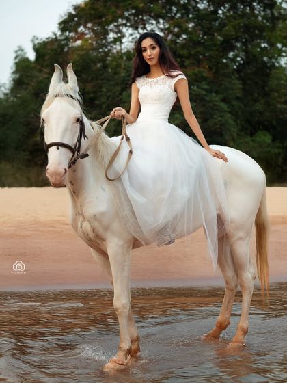 The model and horse stand in the gentle waves of the ocean. This shot required careful timing to capture the right moment as the water washed ashore, adding movement to the scene.