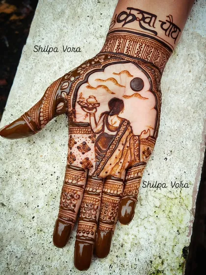 A classic Karwa Chauth design, featuring the traditional scene of a woman with a puja thali looking at the moon. I can incorporate names and other personal elements to make your festive mehndi unique.