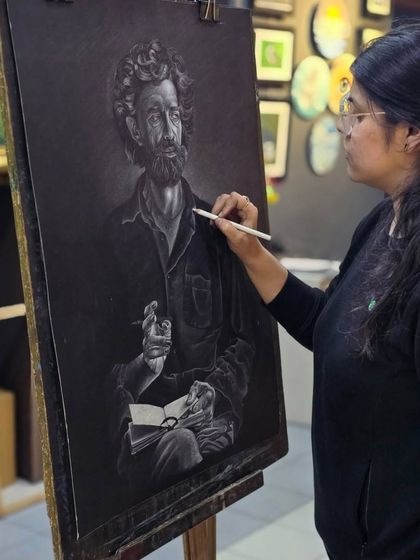 This shot shows the artist adding highlights to the man's shirt, creating realistic folds and shadows with the white pencil.