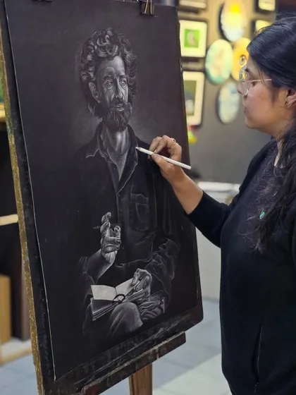 This shot shows the artist adding highlights to the man's shirt, creating realistic folds and shadows with the white pencil.