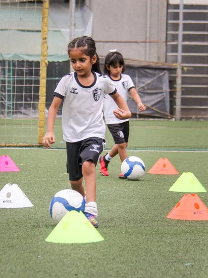 Weaving through a series of cones, these players are honing their dribbling and coordination. Our training sessions include a variety of drills to keep players engaged and constantly improving.