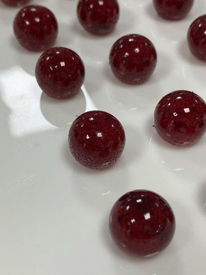 Another look at our cranberry pearls, showing the natural texture and color variation that comes from using real fruit. Each pearl has a crunchy caramelized center.