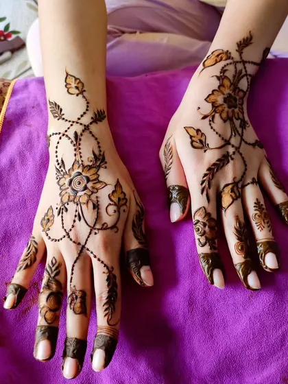 A beautiful "bail" or vine design that crisscrosses the hands, a popular choice for party henna.