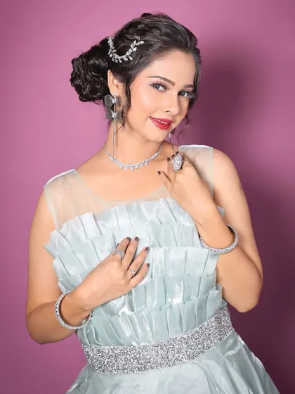 A close-up showing the delicate illusion neckline and the sparkling silver belt that cinches the waist. The rental includes the matching diamond-look jewellery.