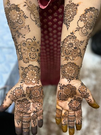 A beautiful example of spaced-out floral clusters for a full-hand look. This design covers the hands and arms with beautiful mandalas and floral motifs without being completely filled in.