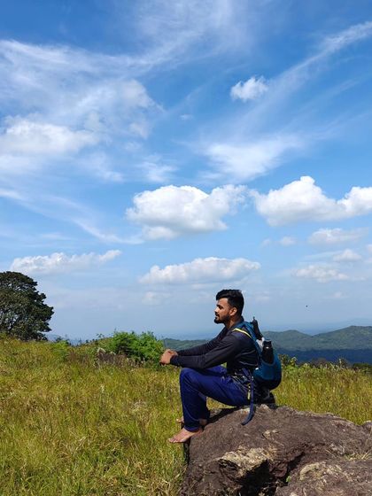 A moment of peace, sitting on a rock and enjoying the view of the sky and hills.