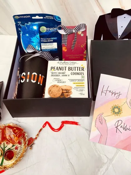 Inside our tuxedo-themed Rakhi box. We've included a grooming kit with a face mask and tan removal cream, a cool mug, cookies, and a personalized card.