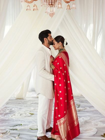 Sonakshi and Zaheer after their ceremony, standing under a simple, elegant canopy of white fabric. The floor, scattered with white petals, added to the pure and timeless feel of this magical union.