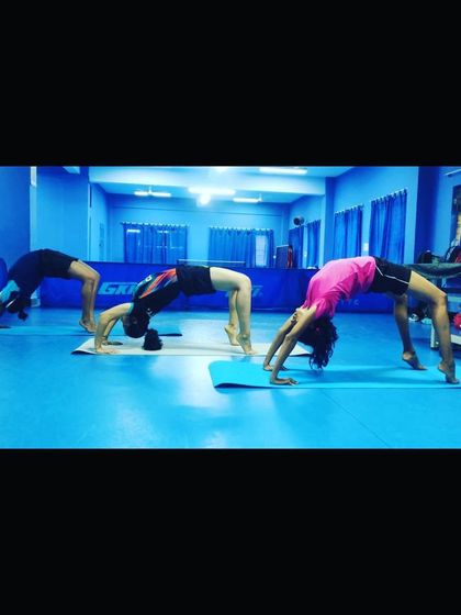 Flexibility is key to preventing injuries and improving reach. Our players are seen here practicing the wheel pose during a yoga session, which helps improve spinal flexibility and shoulder mobility.