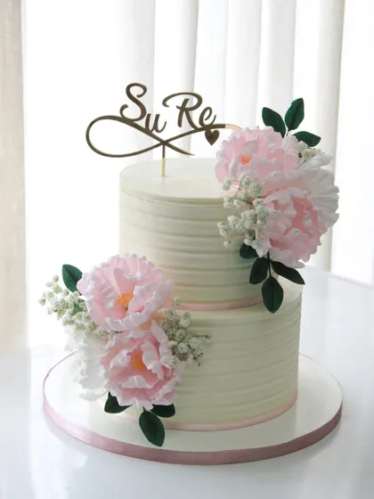A simple and elegant engagement cake with a textured finish and beautiful handmade pink sugar peonies.