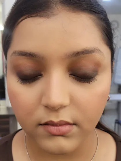 A close-up of the eye makeup, showing the deep brown and black shades blended out for a dramatic yet clean smokey effect.