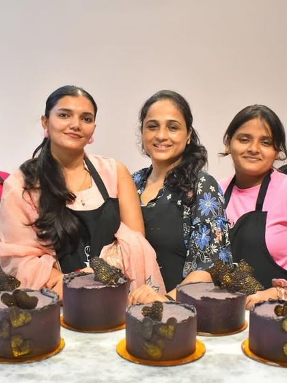 Our talented group of bakers after completing the chocolate ganache module. Each student created their own unique design, from textured hearts to modern sails.