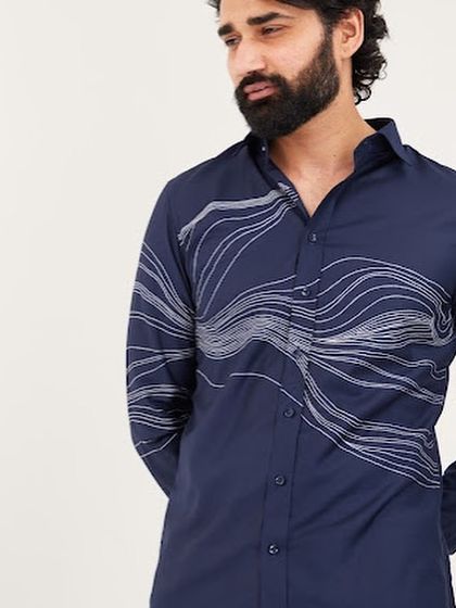 Another view of the navy wave shirt, highlighting the clean finish and the way the abstract design wraps around the body.