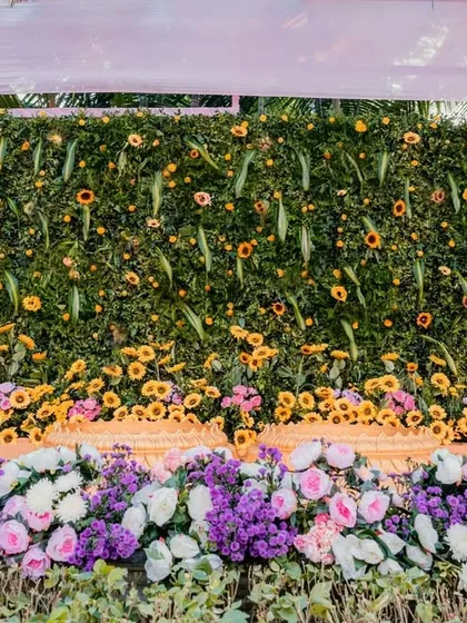 A lush green floral wall serves as a stunning backdrop for the Haldi ceremony. I use a mix of sunflowers, roses, and other seasonal blooms to create a rich, textured, and vibrant photo opportunity.