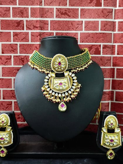 A gorgeous green kundan choker set with pink stone accents, perfect for a mehendi or sangeet.