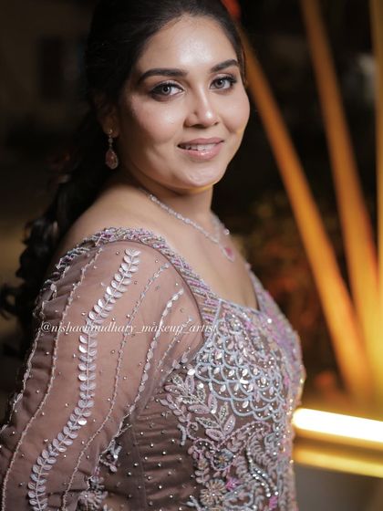 A confident and glamorous sangeet look. The makeup is designed to enhance her features and complement the intricate outfit.