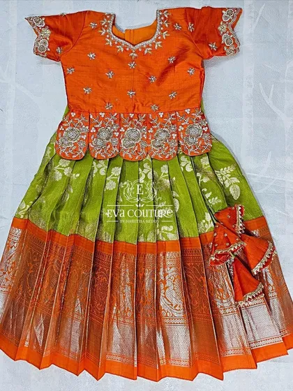 This 6-month-old size Kanchi Pattu lehenga is ready to ship. It features a beautiful orange blouse with silver maggam work.