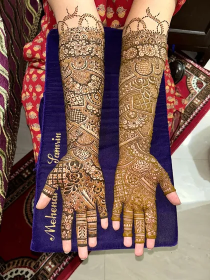 A complete view of a traditional Indian bridal mehendi. The design features different patterns on each arm, creating a unique and personalized look.