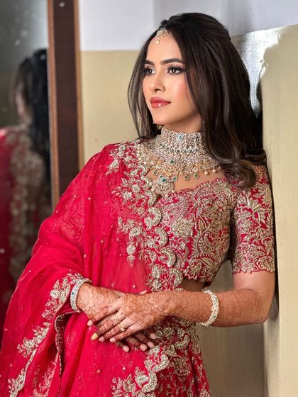 A classic pose by the mirror, showcasing the bride's elegant reception look and her flawless makeup.