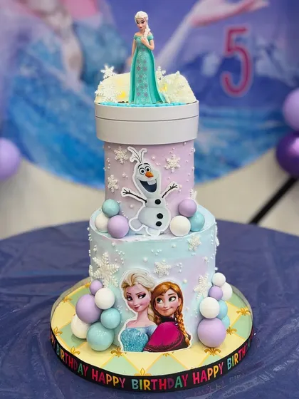Let it go? Never! This magical two-tier Frozen cake features Elsa, Anna, and Olaf, with a special light-up rotating topper for Kiansha's 5th birthday.