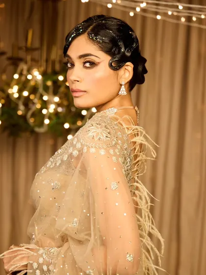 A collection showcasing a unique vintage cocktail look. The glitter-parted finger wave hairstyle and dramatic graphic eyeliner create a memorable and high-fashion statement.