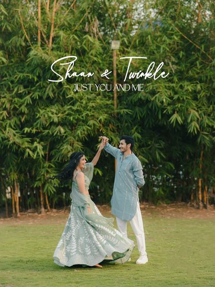 A couple dances joyfully in a lush green garden, dressed in beautiful pastel traditional outfits. This image is full of life, movement, and romance.