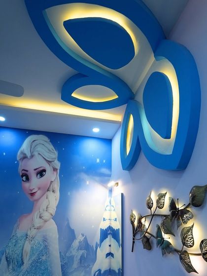 A magical kids' room with a "Frozen" theme, featuring a large wall mural of Elsa and a creative butterfly-shaped false ceiling design.